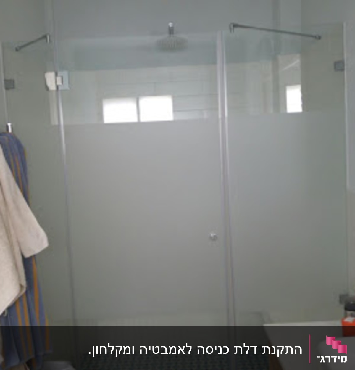 מקלחון זכוכית עם מגבות תלויים בצד